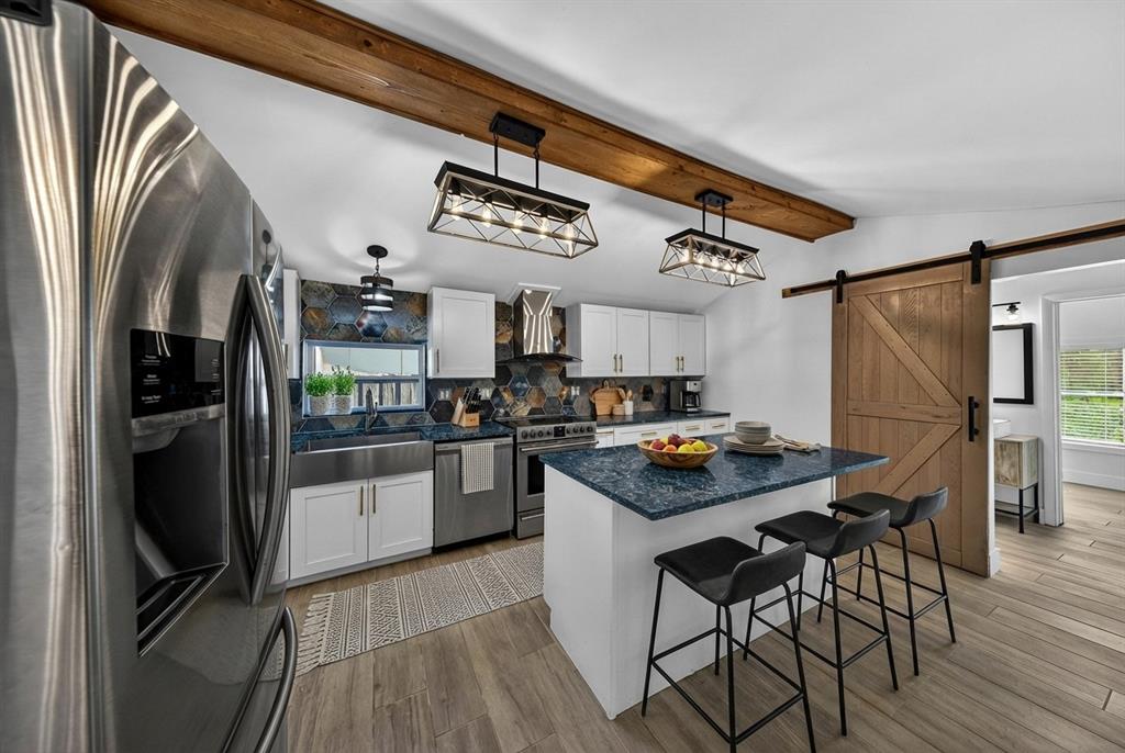 181 Northeast 15th Terrace Boca Raton, FL 33431 - Photo 26 of 51 a kitchen with stainless steel appliances granite countertop a refrigerator a sink dishwasher a stove and white countertops with wooden floor