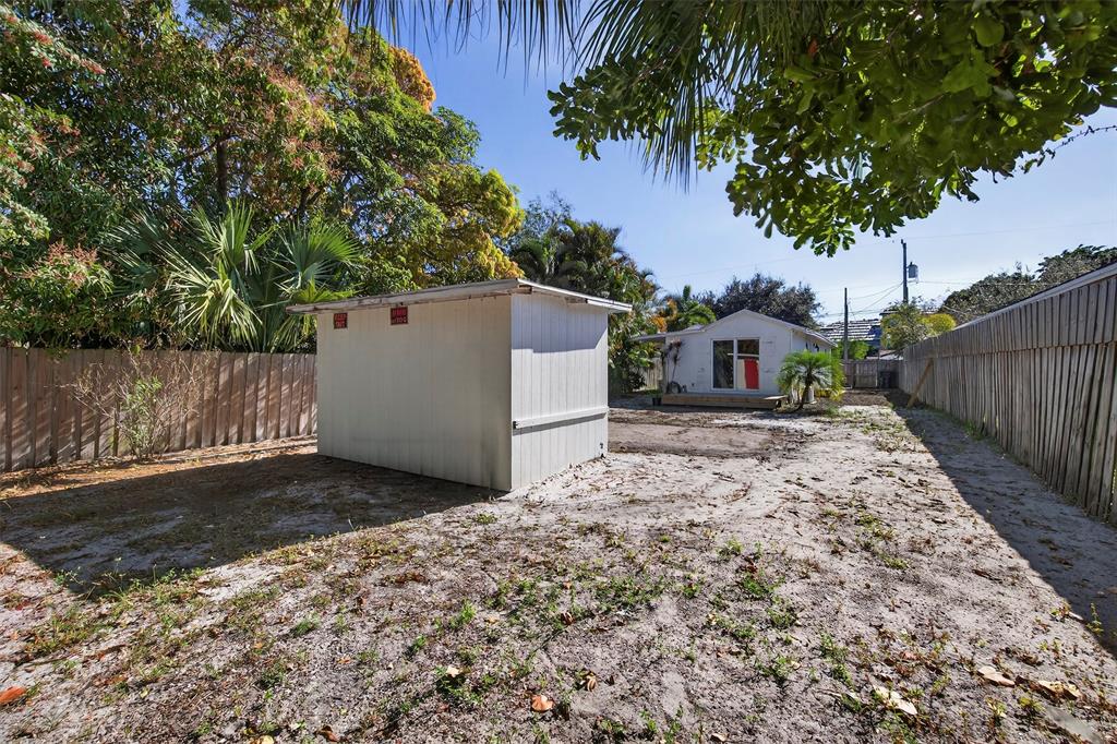 181 Northeast 15th Terrace Boca Raton, FL 33431 - Photo 46 of 51 a backyard of a house with a tree and wooden fence