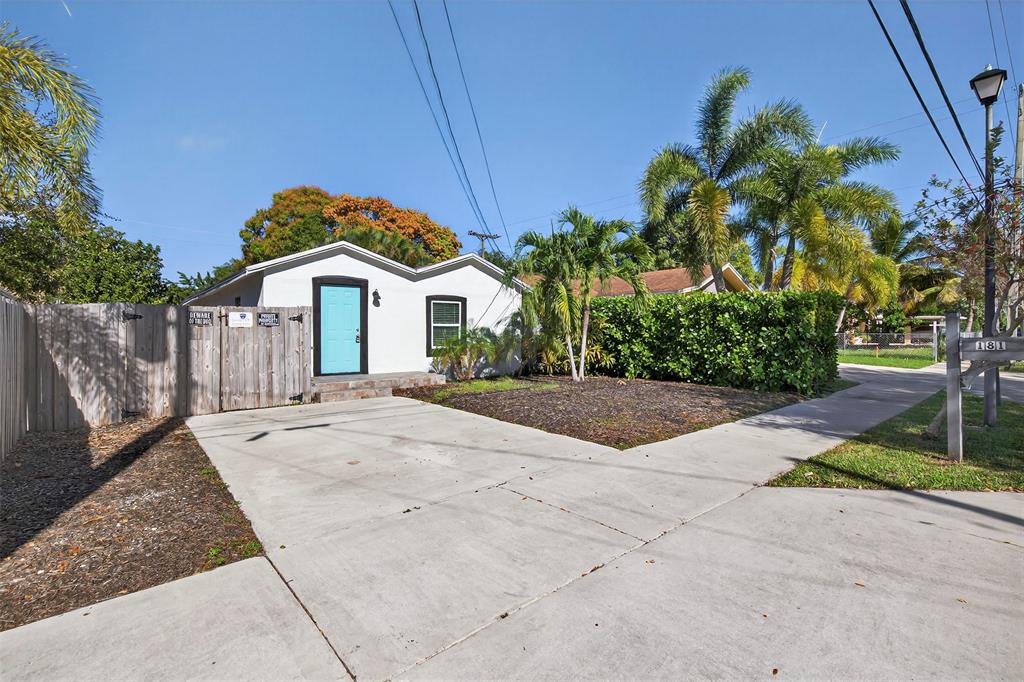 181 Northeast 15th Terrace Boca Raton, FL 33431 - Photo 8 of 51 a front view of a house with a yard and potted plants