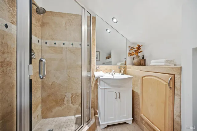 a bathroom with a sink mirror vanity and shower