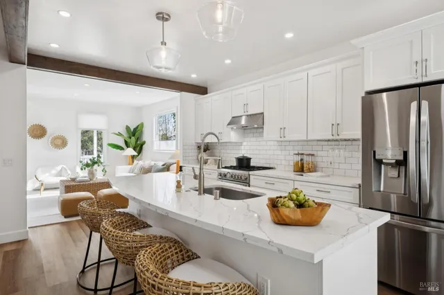 a kitchen with stainless steel appliances granite countertop a sink a stove and a refrigerator