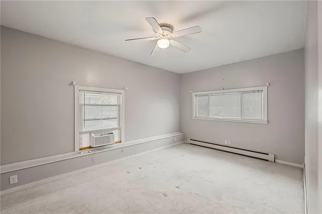 an empty room with closet and windows