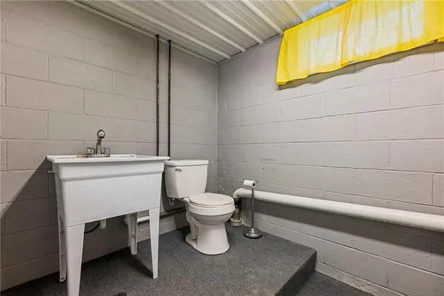 a bathroom with a sink a toilet and mirror