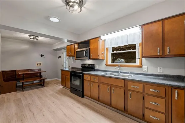 a kitchen with stainless steel appliances a stove sink and microwave