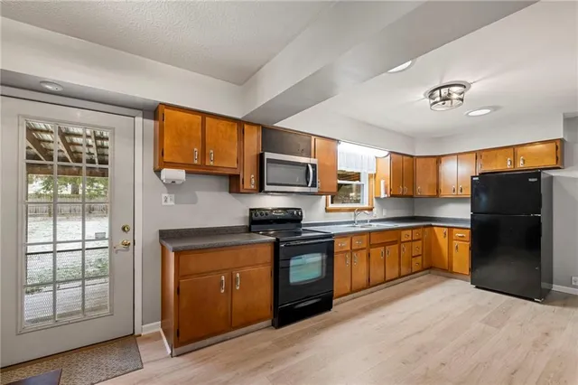 a kitchen with stainless steel appliances granite countertop a refrigerator stove top oven a sink and dishwasher