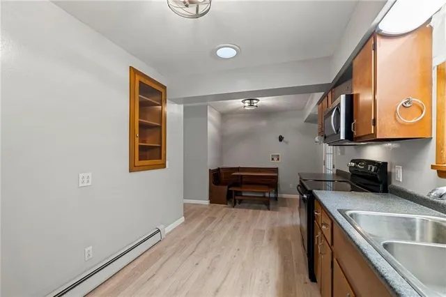 a kitchen with stainless steel appliances granite countertop a sink and wooden cabinets