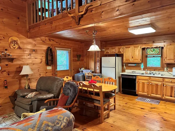 a kitchen with stainless steel appliances kitchen island granite countertop a table chairs and a refrigerator