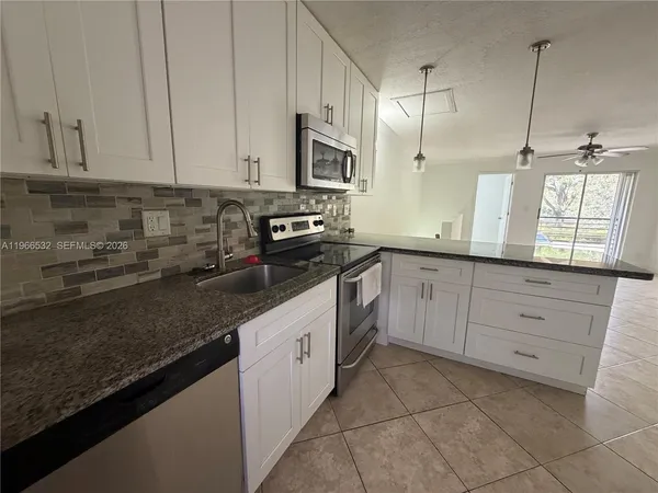a kitchen with stainless steel appliances granite countertop a sink a stove and a granite counter tops