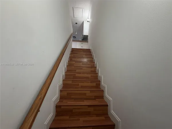 a view of a hallway with wooden floor and entryway