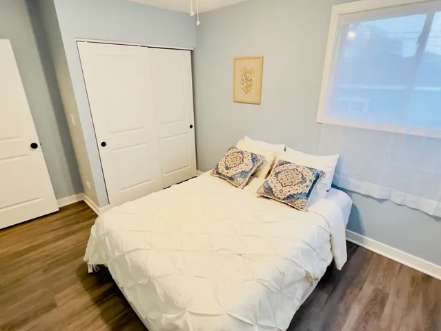 a bedroom with a bed and wooden floor