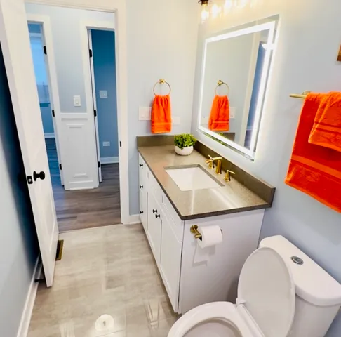 a bathroom with a toilet sink and mirror