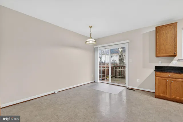 an empty room with windows and cabinet