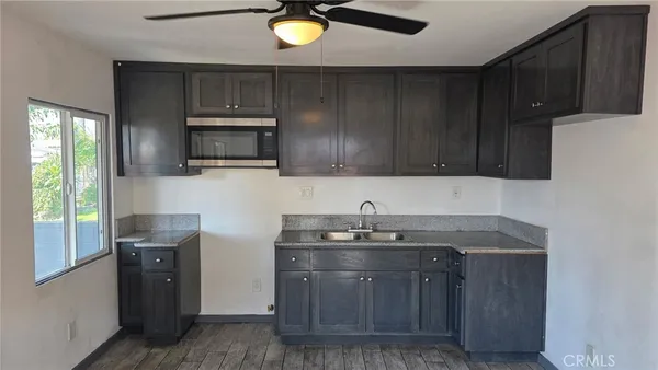 a kitchen with stainless steel appliances granite countertop wooden cabinets a stove top oven a sink and dishwasher