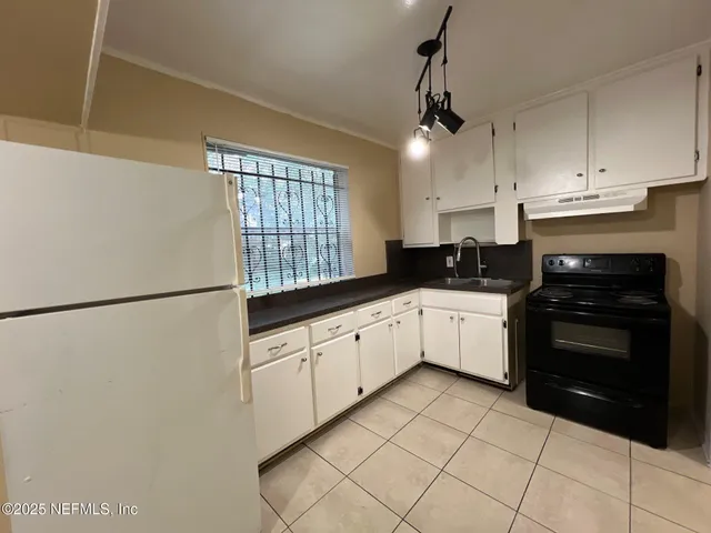 a kitchen with granite countertop white cabinets and white appliances