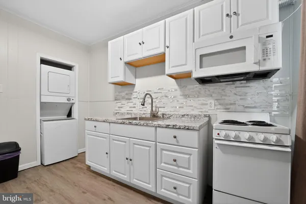 a kitchen with white cabinets and appliances