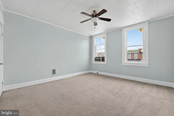 an empty room with window and ceiling fan