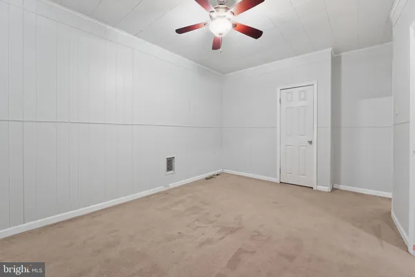 an empty room with chandelier fan