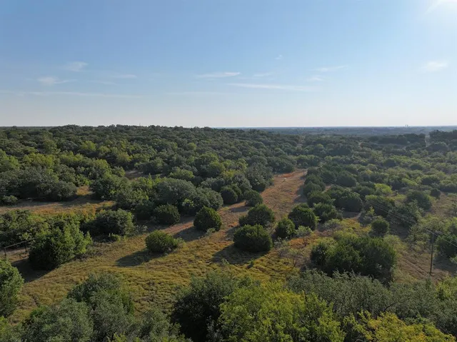 an aerial view of residential houses with outdoor space and trees