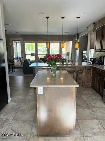 a view of a kitchen with kitchen island stainless steel appliances a stove a sink a counter top dining table and chairs