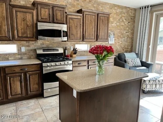 a kitchen with stainless steel appliances a stove a microwave a sink and cabinets