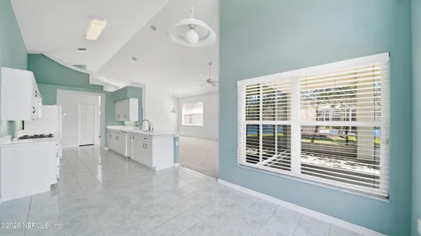 an empty room with a window and ceiling fan