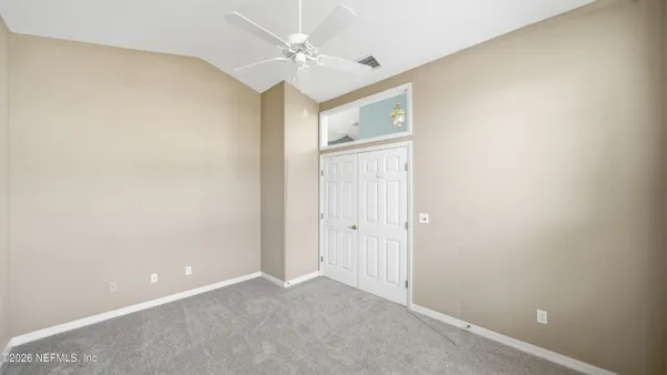 a view of an empty room with a fireplace and a window
