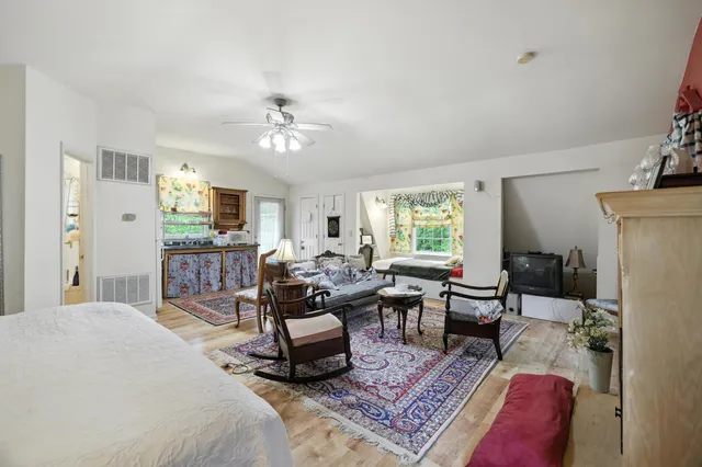 a view of a house with a yard and large tree