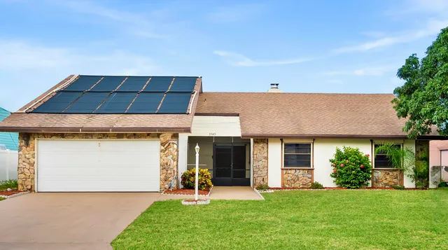 a front view of a house with a garden and yard