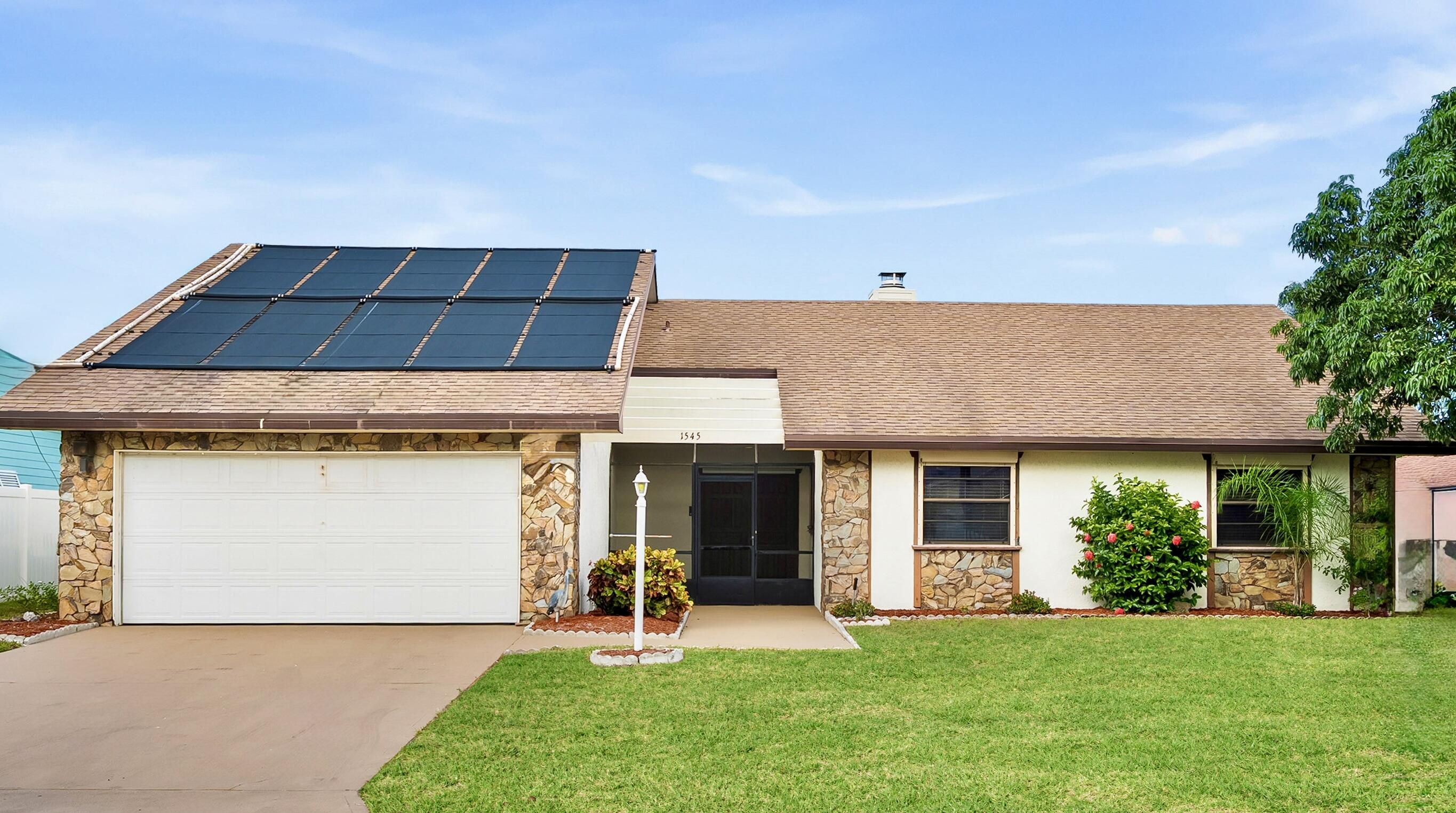 a front view of a house with a garden and yard