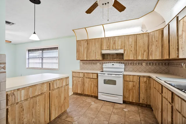 a bedroom with a large bed a chandelier and a flat tv screen
