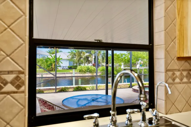 an empty room with chandelier fan and windows