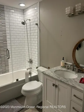 a bathroom with a granite countertop toilet sink and mirror