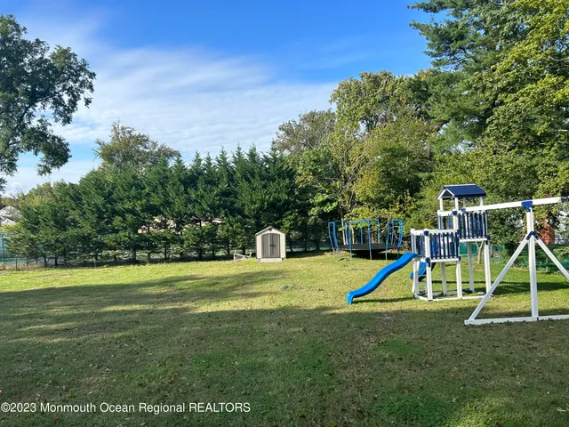 a view of a backyard with a slide and a small park