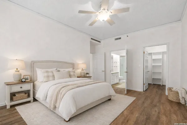 a bedroom with a large bed and wooden floor