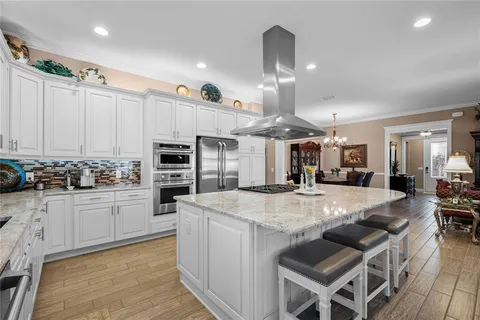 a kitchen with stainless steel appliances granite countertop a stove refrigerator and cabinets