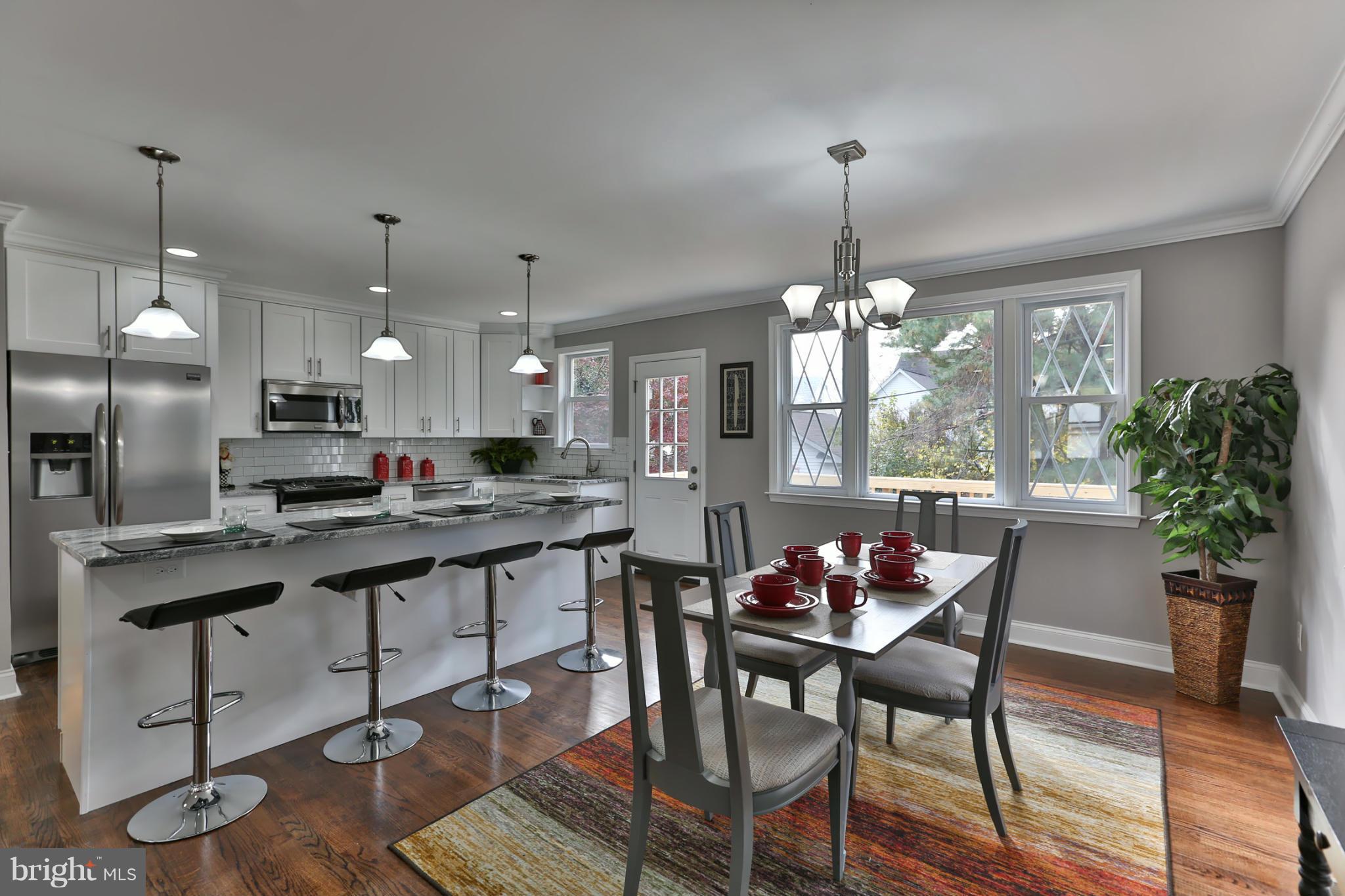 203 Hollen Road Baltimore, MD 21212 - Photo 5 of 30 a kitchen with kitchen island a dining table chairs stainless steel appliances and cabinets
