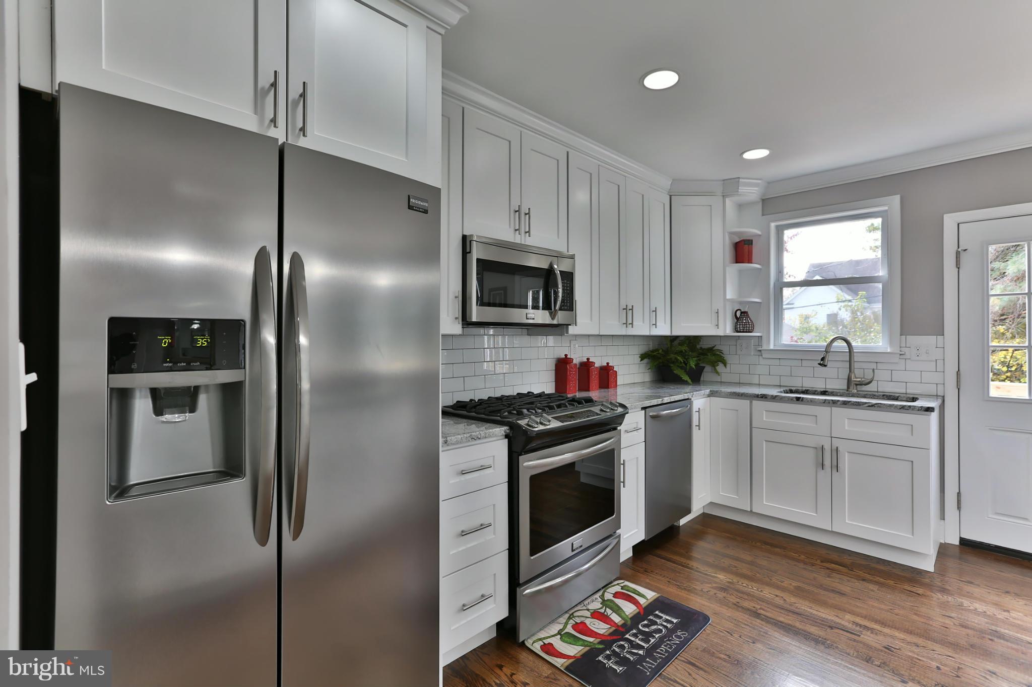 203 Hollen Road Baltimore, MD 21212 - Photo 10 of 30 a kitchen with granite countertop stainless steel appliances and wooden floor