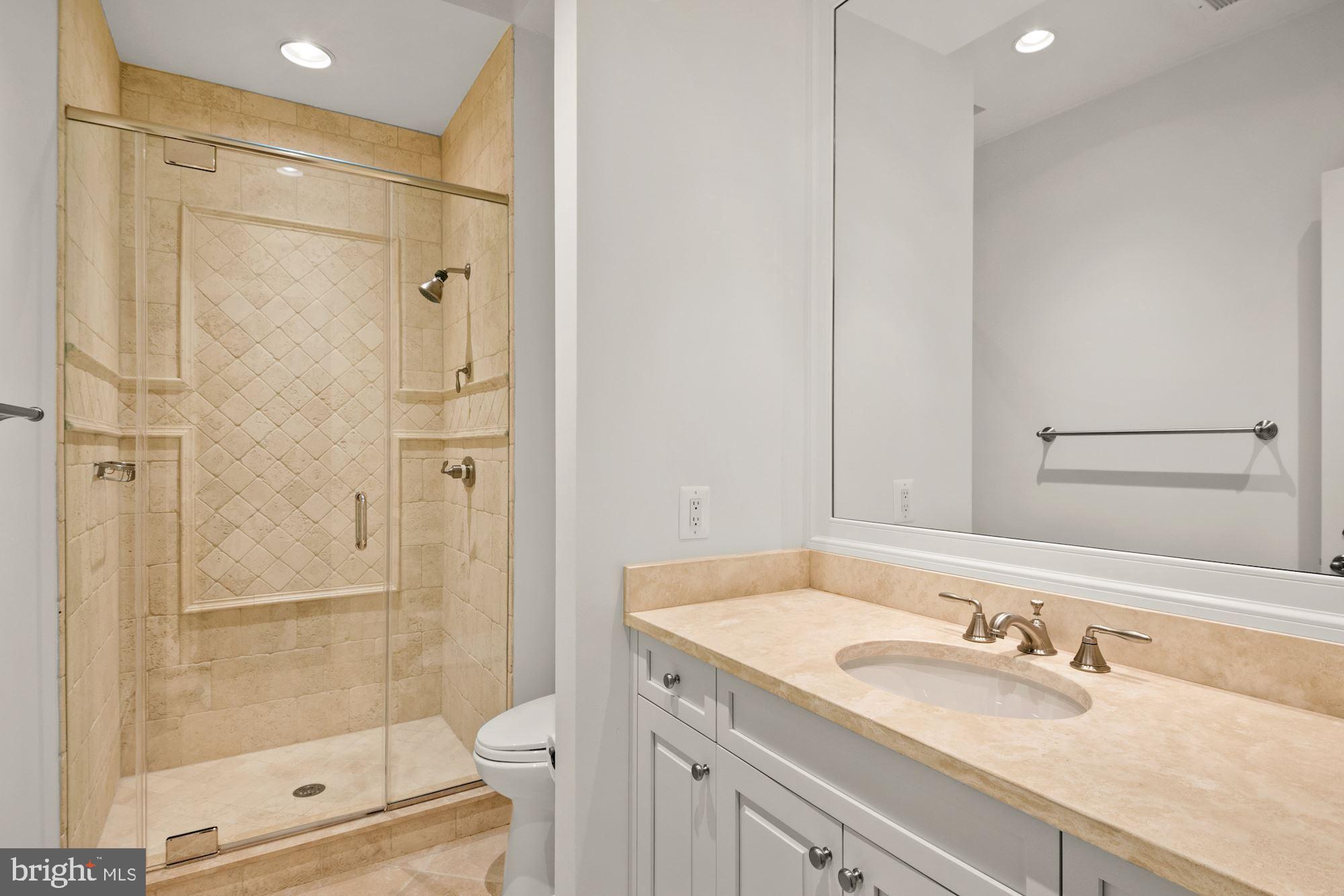 1107 Harvey Road McLean, VA 22101 - Photo 31 of 47 a bathroom with a shower sink and mirror