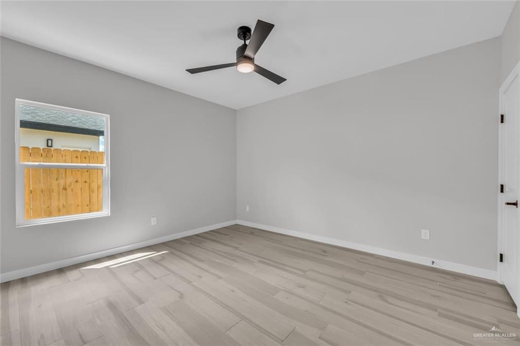 11509 North 25th Street, Unit C McAllen, TX 78504 - Photo 12 of 19 a view of an empty room with wooden floor and a window