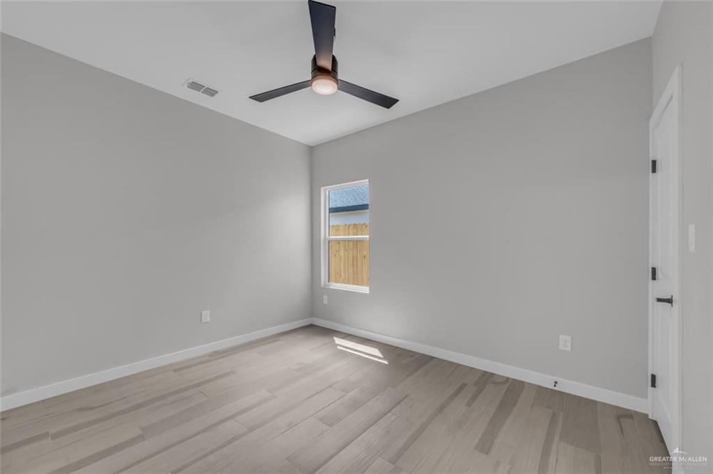 11509 North 25th Street, Unit C McAllen, TX 78504 - Photo 15 of 19 wooden floor in an empty room with a window