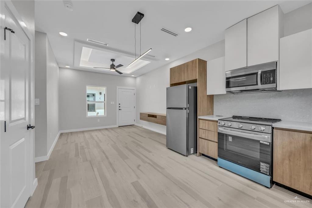 11509 North 25th Street, Unit C McAllen, TX 78504 - Photo 3 of 19 a kitchen with stainless steel appliances granite countertop a refrigerator a stove oven a sink dishwasher and white cabinets with wooden floor
