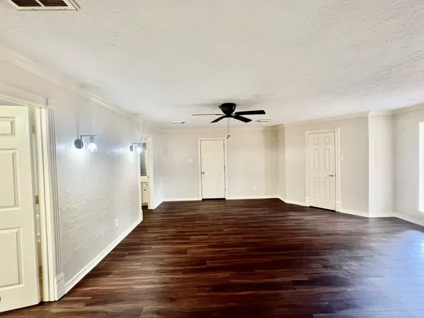 a view of empty room with wooden floor