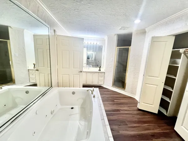 a large white bathroom with a sink a large mirror and shower