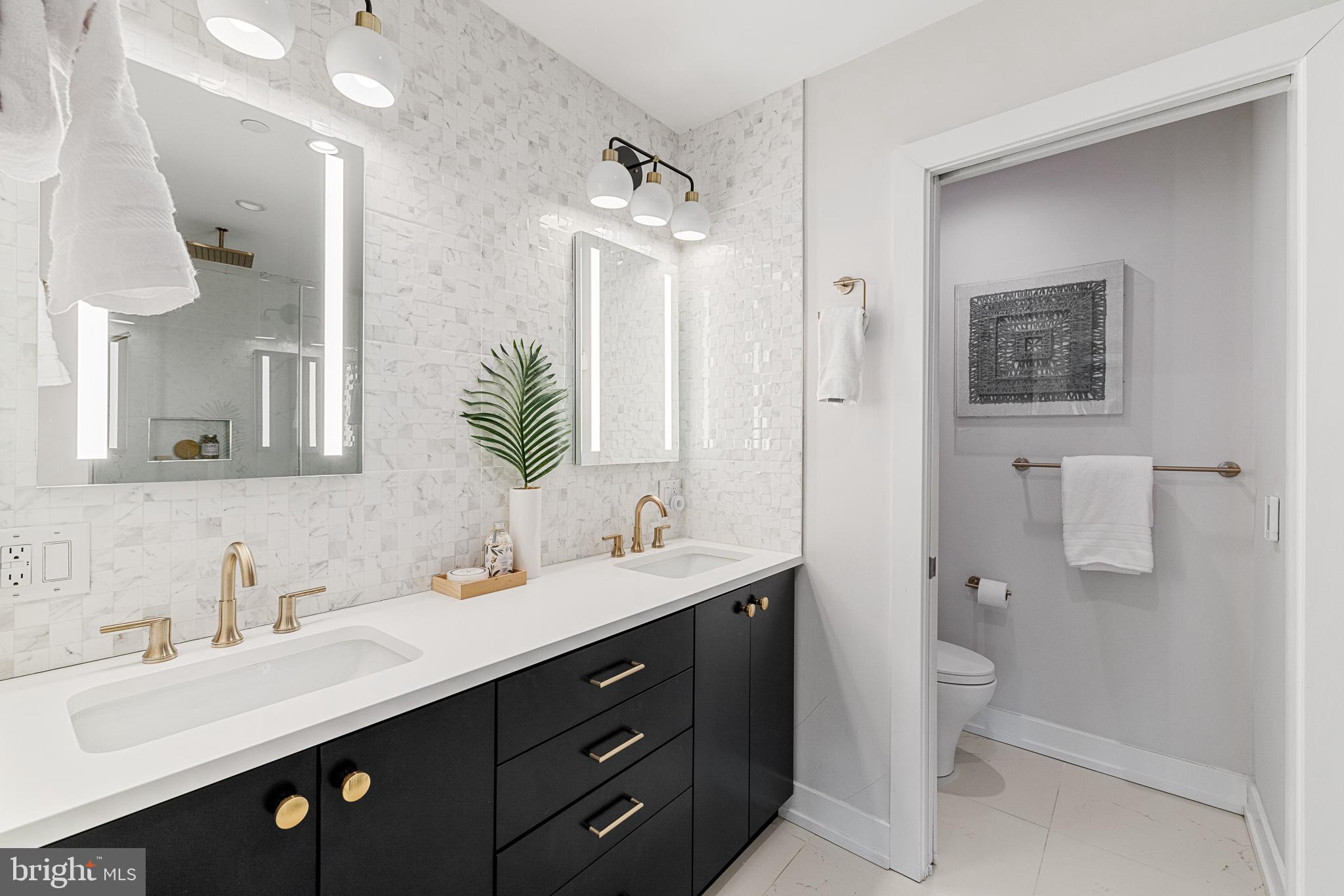 262 South 16th Street, Unit 7 Philadelphia, PA 19102 - Photo 22 of 36 a bathroom with a double vanity sink a mirror and a toilet