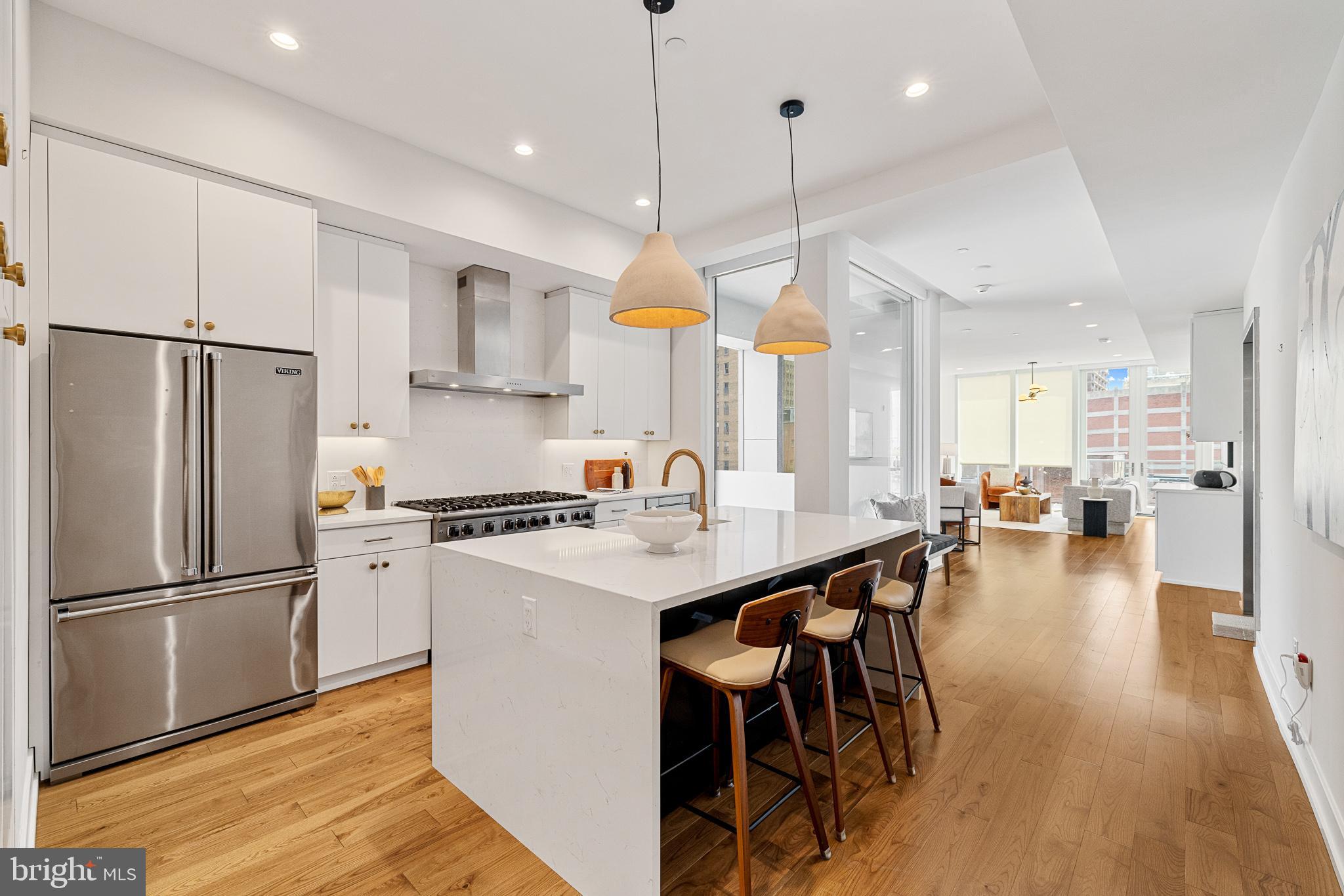 262 South 16th Street, Unit 7 Philadelphia, PA 19102 - Photo 5 of 36 a kitchen with stainless steel appliances granite countertop a refrigerator a sink a stove a dining table and chairs