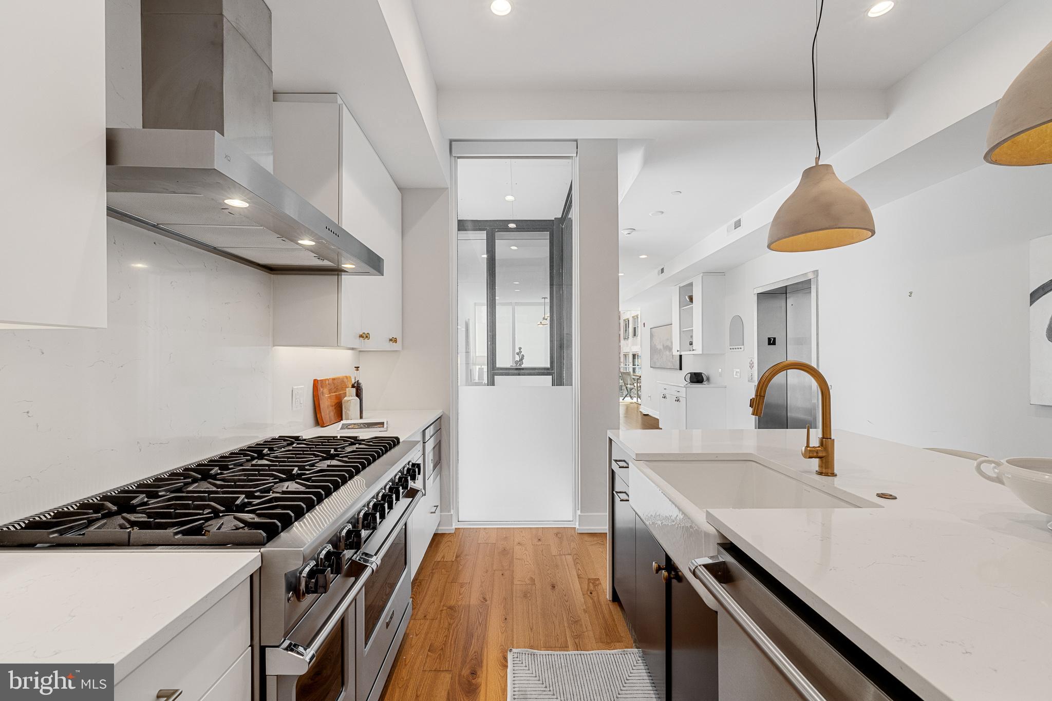 262 South 16th Street, Unit 7 Philadelphia, PA 19102 - Photo 9 of 36 a kitchen with stainless steel appliances a sink a stove and a wooden floors