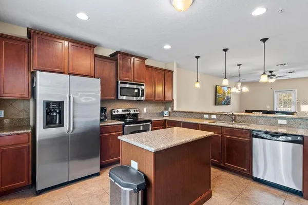 a kitchen with stainless steel appliances granite countertop a sink stove and refrigerator