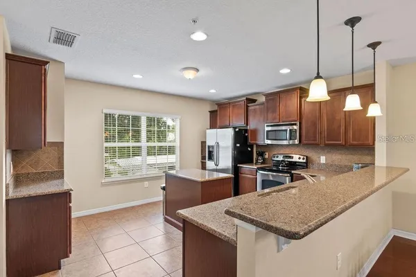a kitchen with stainless steel appliances granite countertop a sink stove and refrigerator