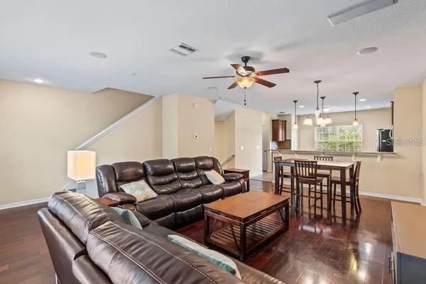 a living room with furniture a dining table and chairs with wooden floor