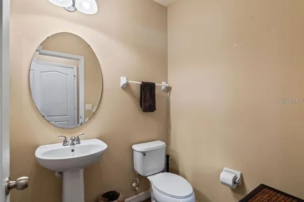 a bathroom with a toilet a sink and mirror